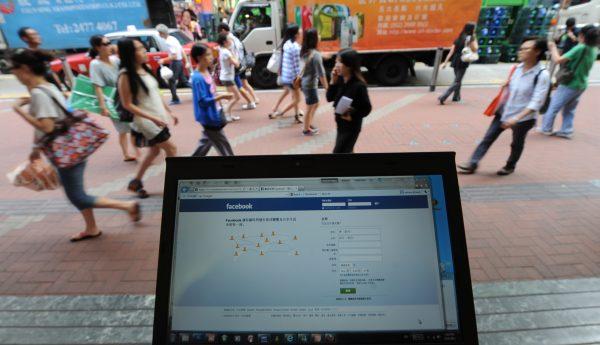 Pedestrians walk past a computer showing the login page for facebook in traditional Chinese characters in Hong Kong on May 14, 2012. (Antony Dickson /AFP/Getty Images)