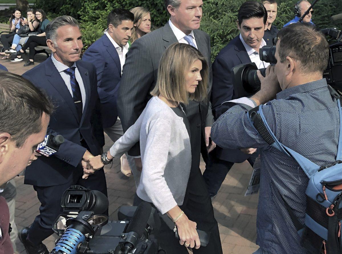 Lori Loughlin (C) departs federal court with her husband, clothing designer Mossimo Giannulli (L) in Boston on Aug. 27, 2019. (AP Photo/Philip Marcelo)