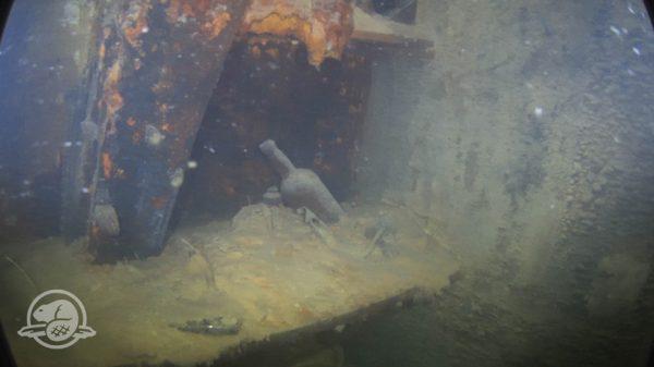 Bottles and other artifacts on a shelf in a cabin on HMS Terror’s lower deck. (Underwater Archaeology Team/Parks Canada)