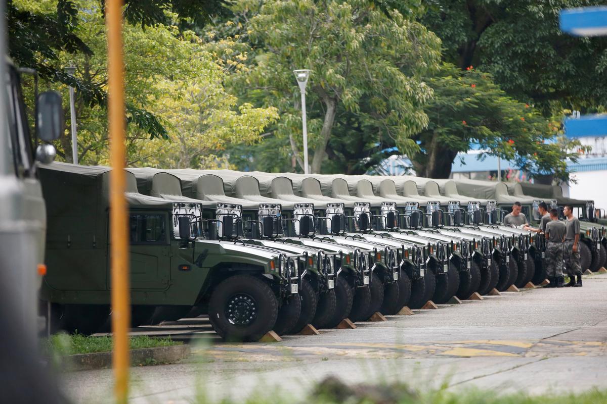 Troops are seen by a row of over a dozen army jeeps at the Shek Kong military base of People's Liberation Army (PLA) in New Territories, Hong Kong, China on Aug. 29, 2019. (Reuters)