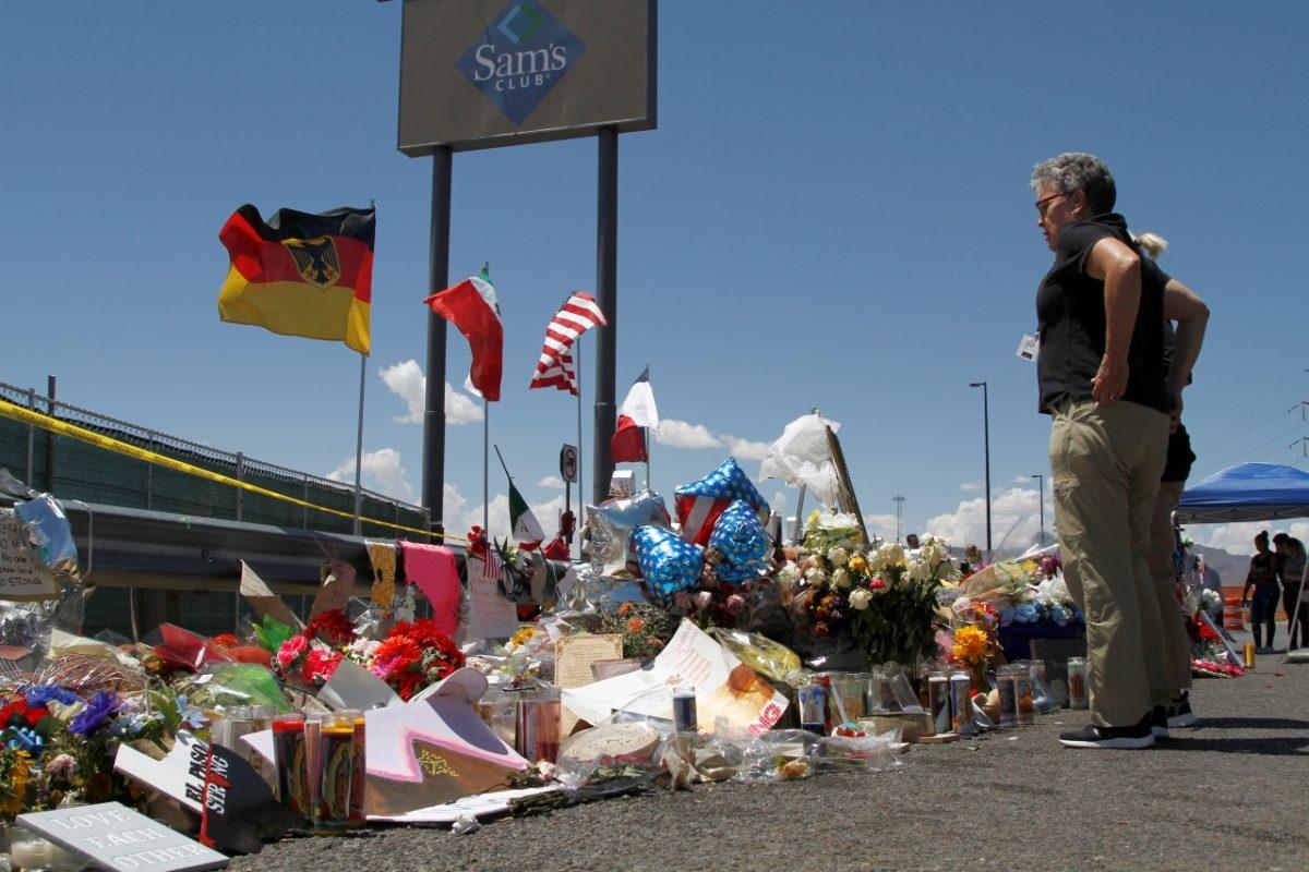 Mourners visit the makeshift memorial near the Walmart where 22 people were killed in a mass shooting in El Paso, Texas, on Aug. 12, 2019. The flags show the nationalities of those killed. (Cedar Attanasio/AP Photo)