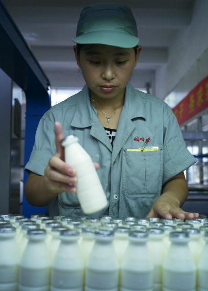 A worker checks milk products at the product line in a factory of Hangzhou Wahaha Group in China. (Photo by China Photos/Getty Images)