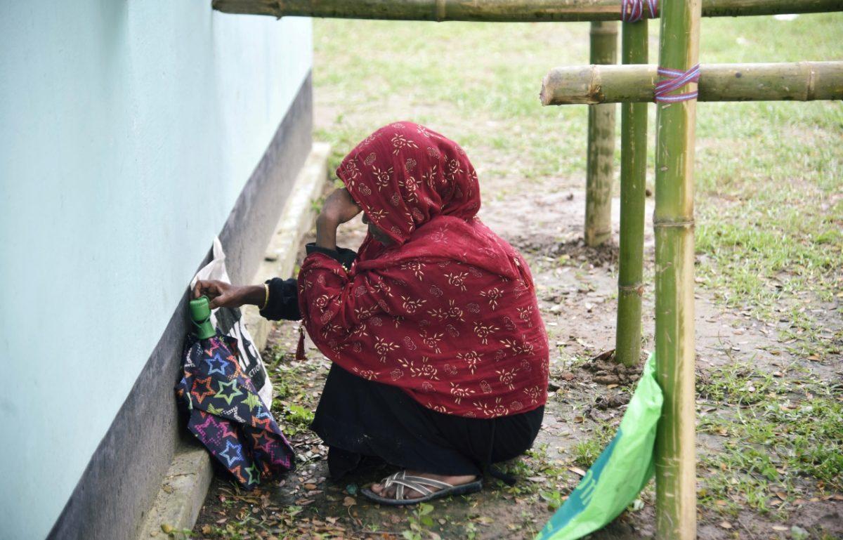 A woman waits to check her name on the draft list of the National Register of Citizens (NRC), as she sits outside an NRC centre in Rupohi village, Nagaon district, northeastern state of Assam, India, on Aug. 31, 2019. (Anuwar Hazarika/Reuters)