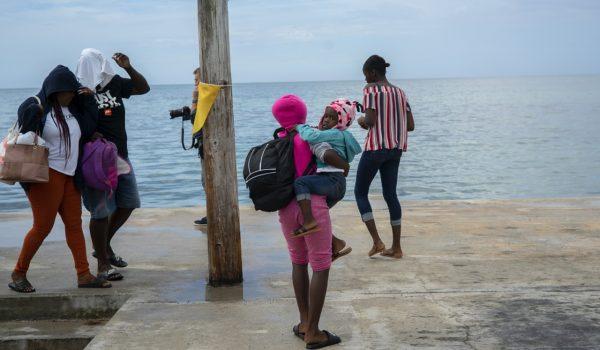 A woman carries a girl in her arms after being evacuated from a nearby Cay due to the danger of floods after arrive on a ship at the port before the arrival of Hurricane Dorian in Sweeting's Cay, Grand Bahama, Bahamas, on Aug. 31, 2019. (Ramon Espinosa/AP Photo)