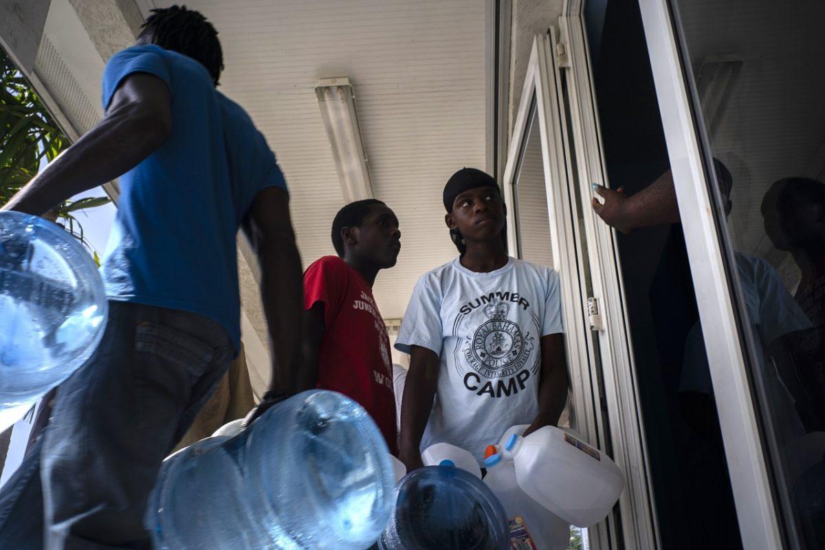 People line up to buy water at a store before the arrival of Hurricane Dorian, in Freeport, Bahamas, on Aug. 30, 2019. (AP Photo/Ramon Espinosa)