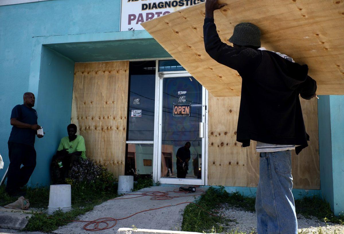 Workers board up a shop’s window front as they make preparations for the arrival of Hurricane Dorian, in Freeport, Bahamas, on Aug. 30, 2019. (AP Photo/Ramon Espinosa)