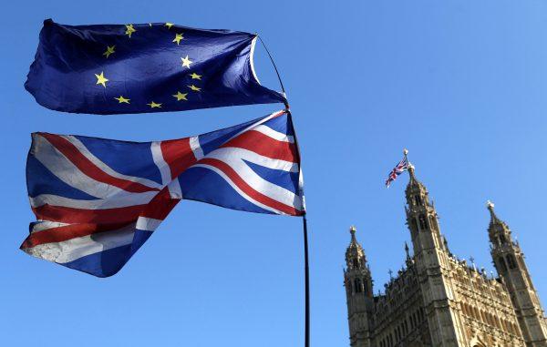 The flag of the European Union and the British national flags are flown during a demonstration by Remain, outside the Palace of Westminster in London on Feb. 27, 2019. (AP Photo/Alastair Grant)