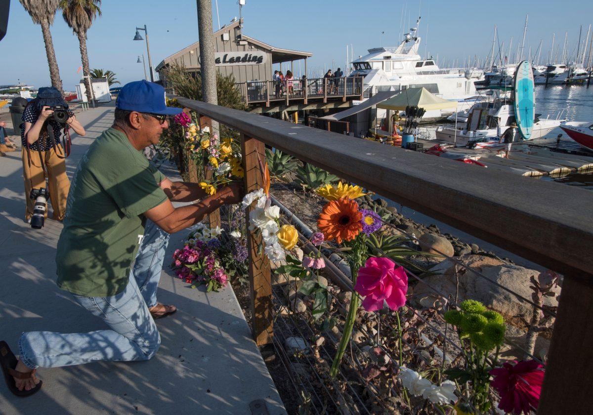 A man places flowers at a memorial wall near the Truth Aquatics moorings where the boat that burned and sank off the Santa Cruz islands early in the morning, was based in Santa Barbara, California on Sept. 2, 2019. (Mark Ralston/AFP/Getty Images)