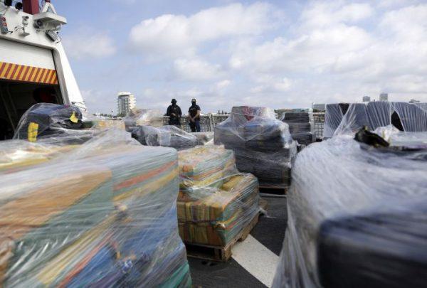 Coast Guardsmen standing over pallets of more than 26 tons of seized cocaine worth at least $715 million, in Fort Lauderdale, Fla., on Dec. 15, 2016. (Lynne Sladky/AP Photo)