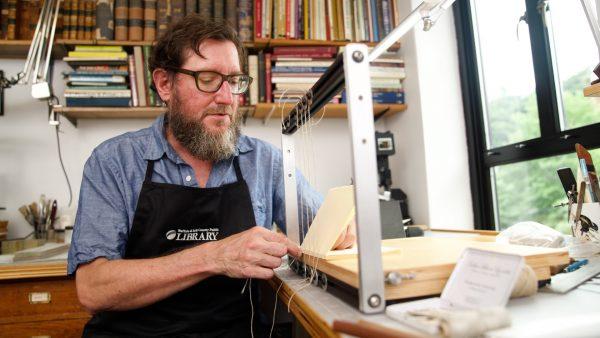 Jeff Peachey shows how to binds books with his self-made sewing frame. (Shenghua Sung/NTD Television)