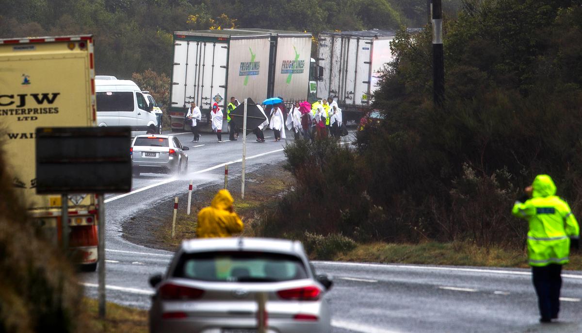 Survivors from a tourist bus crash walk along the highway in the Mamaku Ranges near Rotorua, New Zealand on Sept. 4. 2019. (Ben Fraser/Rotorua Daily Post via AP)