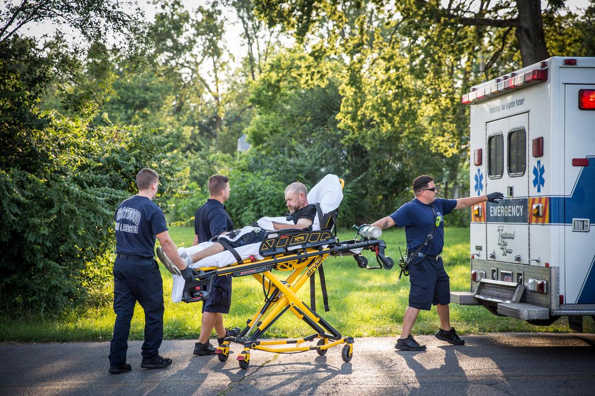 Paramedics help a man who is overdosing in the Drexel neighborhood of Dayton, Ohio, on Aug. 3, 2017. (Benjamin Chasteen/The Epoch Times)