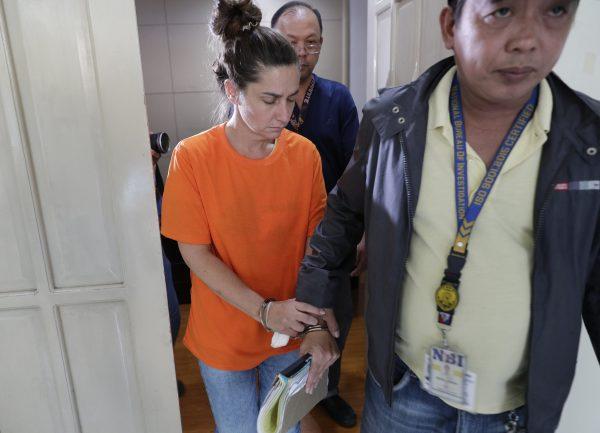 American Jennifer Erin Talbot s escorted after a press conference by the National Bureau of Investigation (NBI) in Manila, Philippines on Sept. 5, 2019. (AP Photo/Aaron Favila)