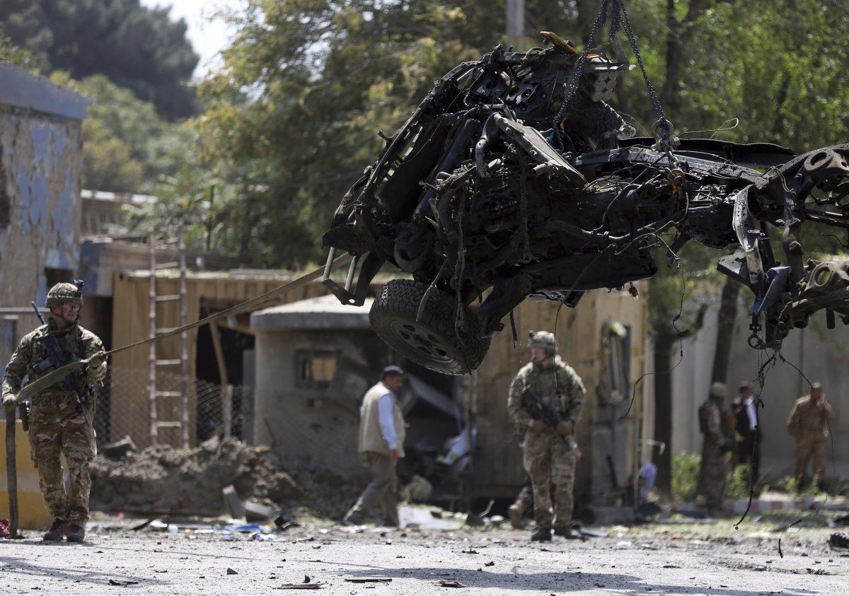Resolute Support (RS) forces remove a damaged vehicle after a car bomb explosion in Kabul, Afghanistan on Sept. 5, 2019. (Rahmat Gul/AP Photo)