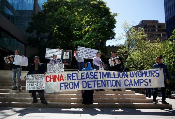 People hold signs protesting China's treatment of the Uyghur people during a court appearance by Huawei's Financial Chief Meng Wanzhou, outside of British Columbia Supreme Court building in Vancouver, British Columbia, Canada on May 8, 2019. (Lindsey Wasson/Reuters)