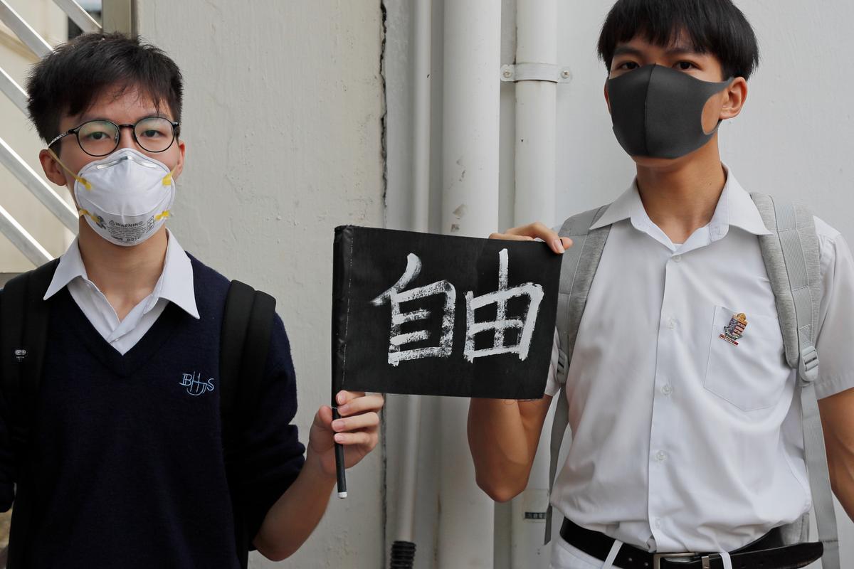 Students hold a placard reads "Freedom" as they form human chain outside a school in Hong Kong on Sept. 6, 2019. (Kin Cheung/AP)