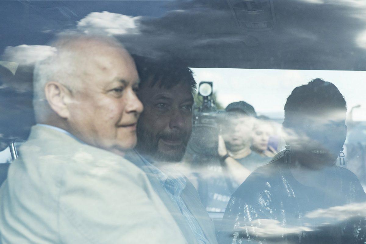 Kirill Vyshinskiy, center, former bureau chief of RIA Novosti news agency in Ukraine, and Rossiya Segodnya director-general Dmitry Kiselyov, left, leave Vnukovo airport in Moscow, Russia,  on Sept. 7, 2019. (AP Photo/Pavel Golovkin)