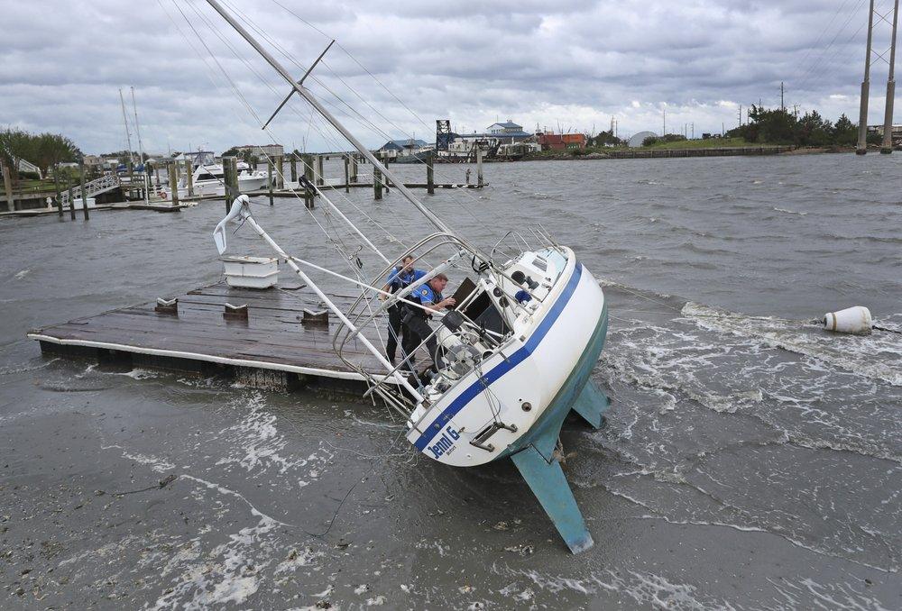 Beaufort Police Officer Curtis Resor, left, and Sgt. Micheal Stephens check a sailboat for occupants in Beaufort, N.C. after Hurricane Dorian passed the North Carolina coast on Sept. 6, 2019. (Tom Copeland/AP Photo)