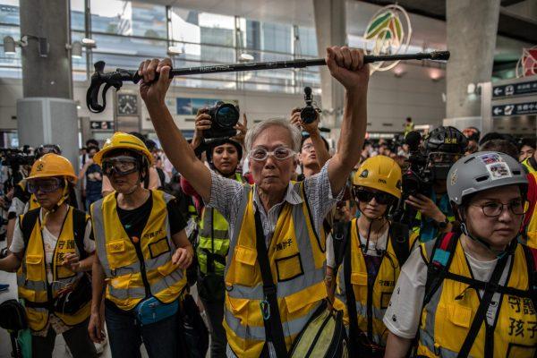An elderly Hongkonger holds up a stick as he stands between police and young protesters during a demonstration at Hong Kong's Tung Chung station on Sept. 7, 2019. (Carl Court/Getty Images)