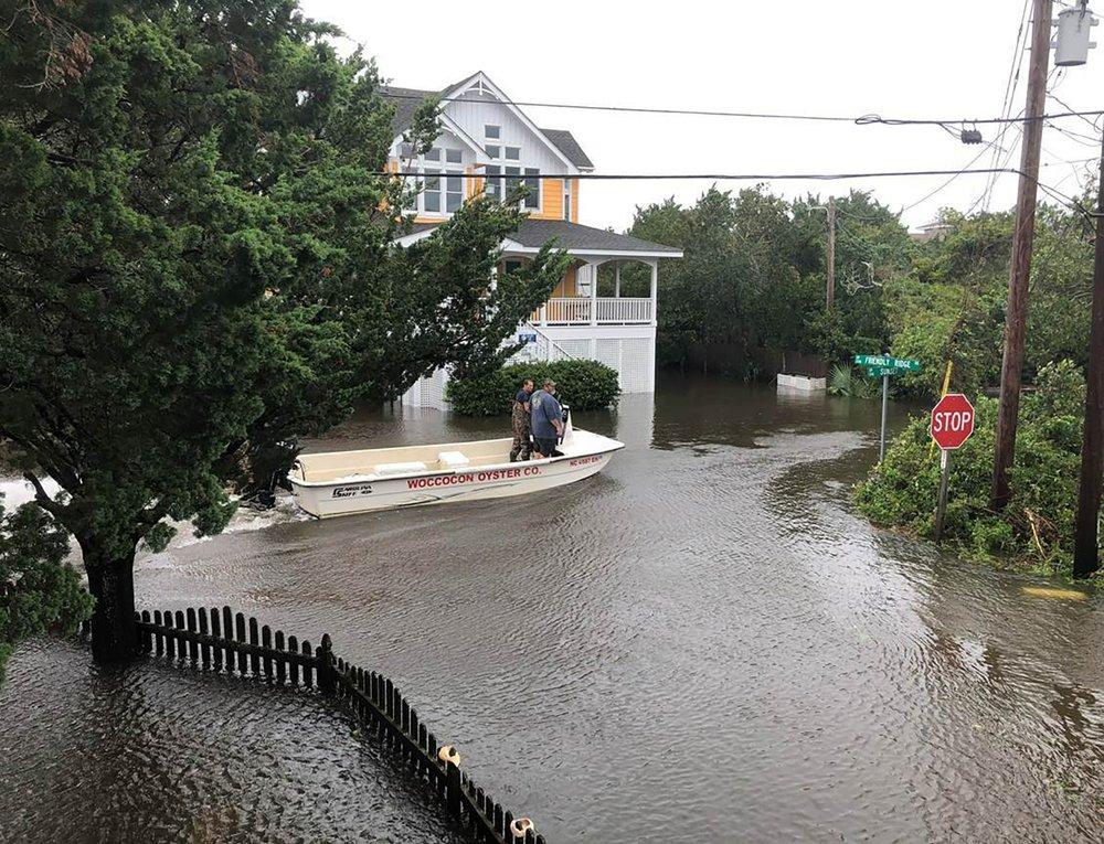 Ocracoke Volunteer Fire Department chief Albert O’Neal boats down Sunset Drive on his way to seek out islanders stranded in their flooded homes in the aftermath of Hurricane. Dorian, on Ocracoke Island, N.C., on Sept. 6, 2019. (Connie Leinbach/Ocracoke Observer via AP)