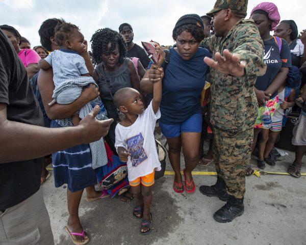Royal Bahamas Defense Forces and Royal Bahamas Police help evacuees move to an awaiting ferry boat at Marsh Harbour Port in Abaco, Bahamas, on Sept. 6, 2019. (Al Diaz/Miami Herald via AP)