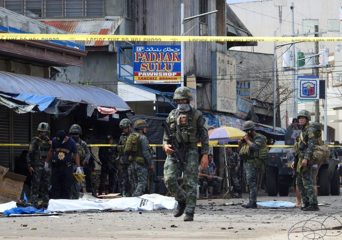 Policemen and soldiers keep watch in a cordoned area outside a church in Jolo, Sulu province on the southern island of Mindanao, Philippines, on Jan. 27, 2019. (Nickee Butlangan/AFP/Getty Images)