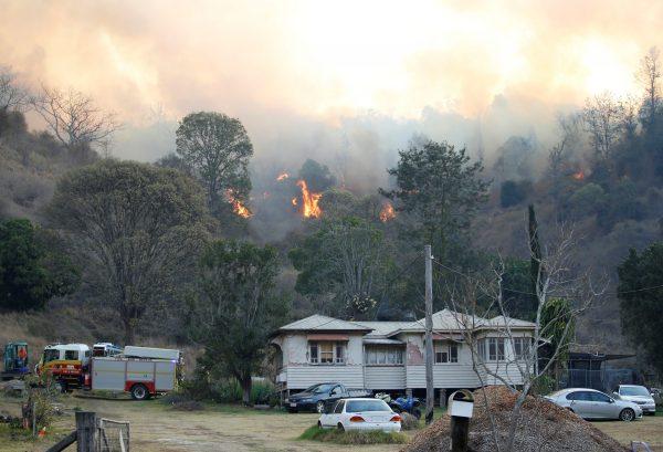 Fire and Emergency crew battle bushfire near a house in the rural town of Canungra in the Scenic Rim region of South East Queensland, Australia, on Sept. 6, 2019. (Regi Varghese/AAP/via REUTERS)