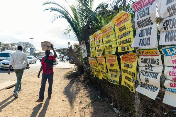 Pedestrians walk past signs of the various daily newspapers on the streets of Harare, Zimbabwe, on Sept. 7 2019, on the first day of a period of national mourning following the death of former Zimbabwe President Robert Mugabe, guerrilla hero turned despot who ruled Zimbabwe for 37 years. (Jekesai Njikizana/AFP/Getty Images)