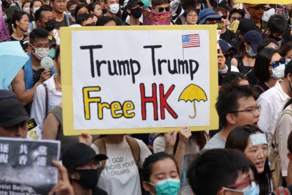 A protester holds up a sign urging U.S. President Trump to free Hong Kong on Sept. 8, 2019. (Yu Gang/The Epoch Times)
