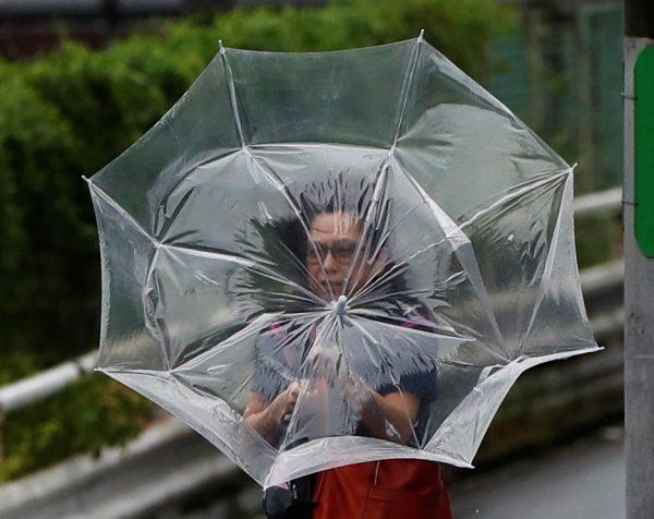 A woman using an umbrella struggles against a heavy rain and wind caused by Typhoon Faxai in Tokyo, Japan, on Sept. 9, 2019. (REUTERS/Issei Kato)