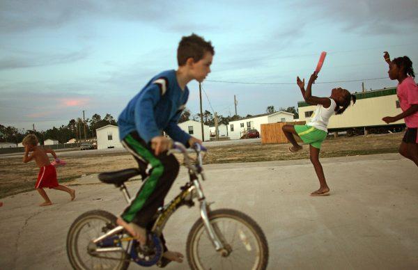 Children play in the FEMA trailer park where they live after their homes were destroyed by Hurricane Katrina in Waveland, Miss., May 27, 2006. (Photo by Mario Tama/Getty Images)