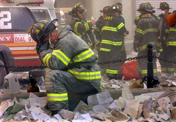 A firefighter breaks down after the World Trade Center buildings collapsed Sept. 11, 2001, after two hijacked airplanes slammed into the twin towers in a terrorist attack that killed some 3,000 people. (Photo by Mario Tama/Getty Images)