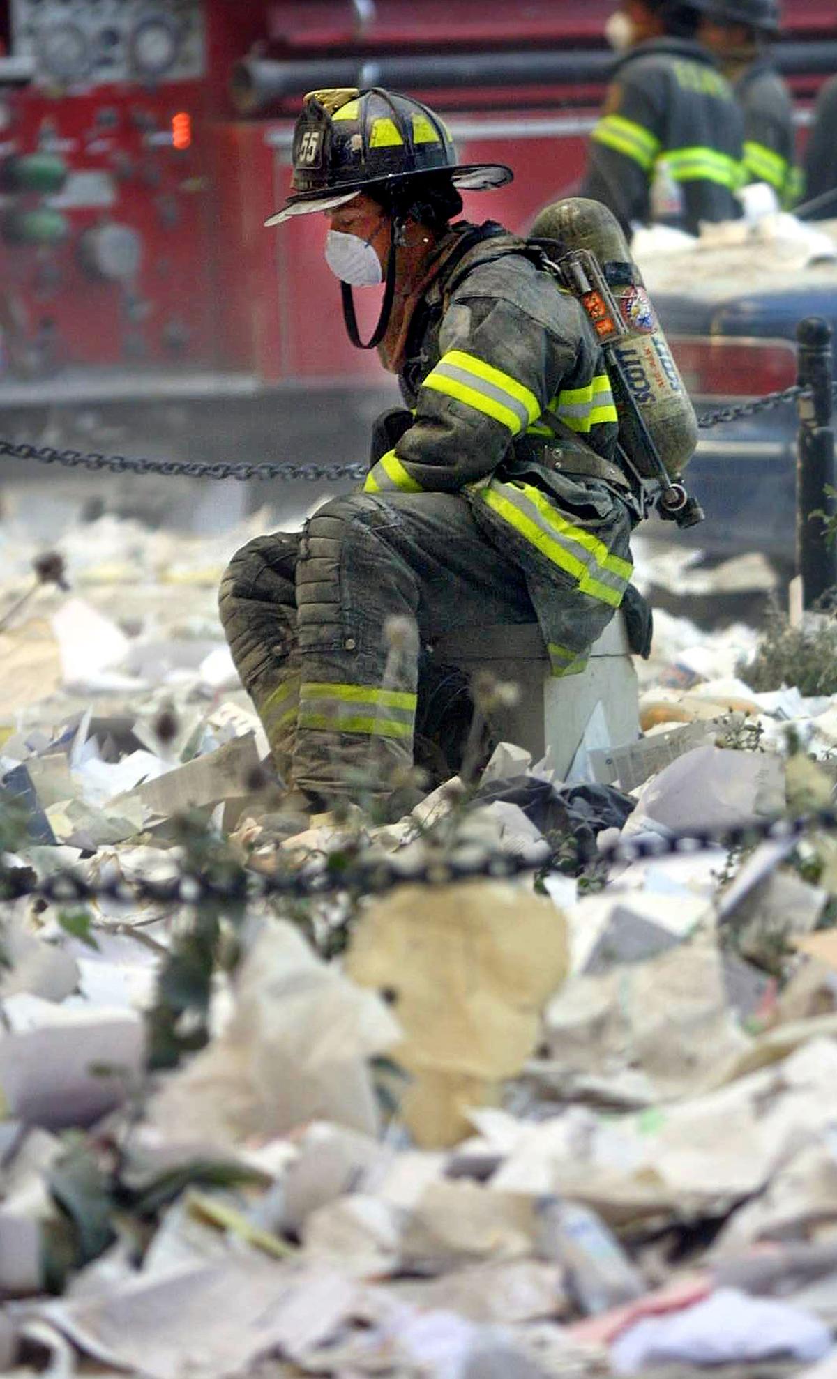 A firefighter rests in the area where the World Trade Center buildings collapsed on Sept. 11, 2001 after two airplanes slammed into the twin towers in a terrorist attack. (Mario Tama/Getty Images)