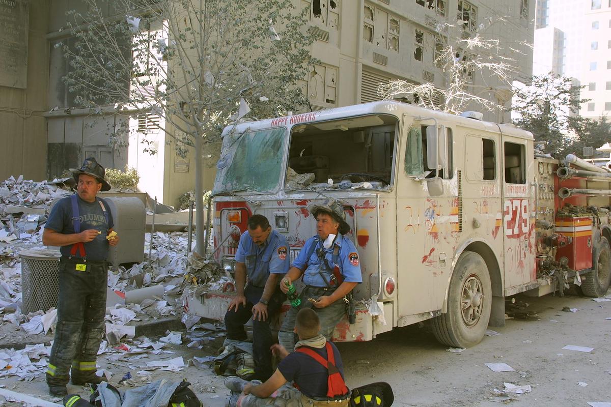 New York City firefighters take a rest at the World Trade Center after two hijacked planes crashed into the Twin Towers in New York City on Sept. 11, 2001. (Ron Agam/Getty Images)