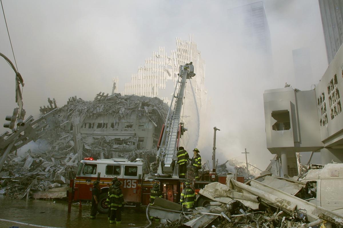 New York City firefighters work at the World Trade Center after two hijacked planes crashed into the Twin Towers in New York City on Sept. 11, 2001. (Photo by Ron Agam/Getty Images)