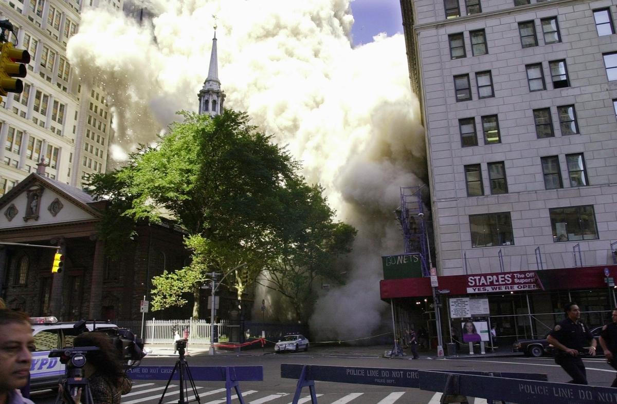 A wall of dust and smoke races through streets framed by St. Paul's Chapel (L) and the Astor Building (R) as the top of one of World Trade Center towers collapses after two planes crashed into the buildings in New York on Sept. 11, 2001. (Stan Honda/AFP/Getty Images)