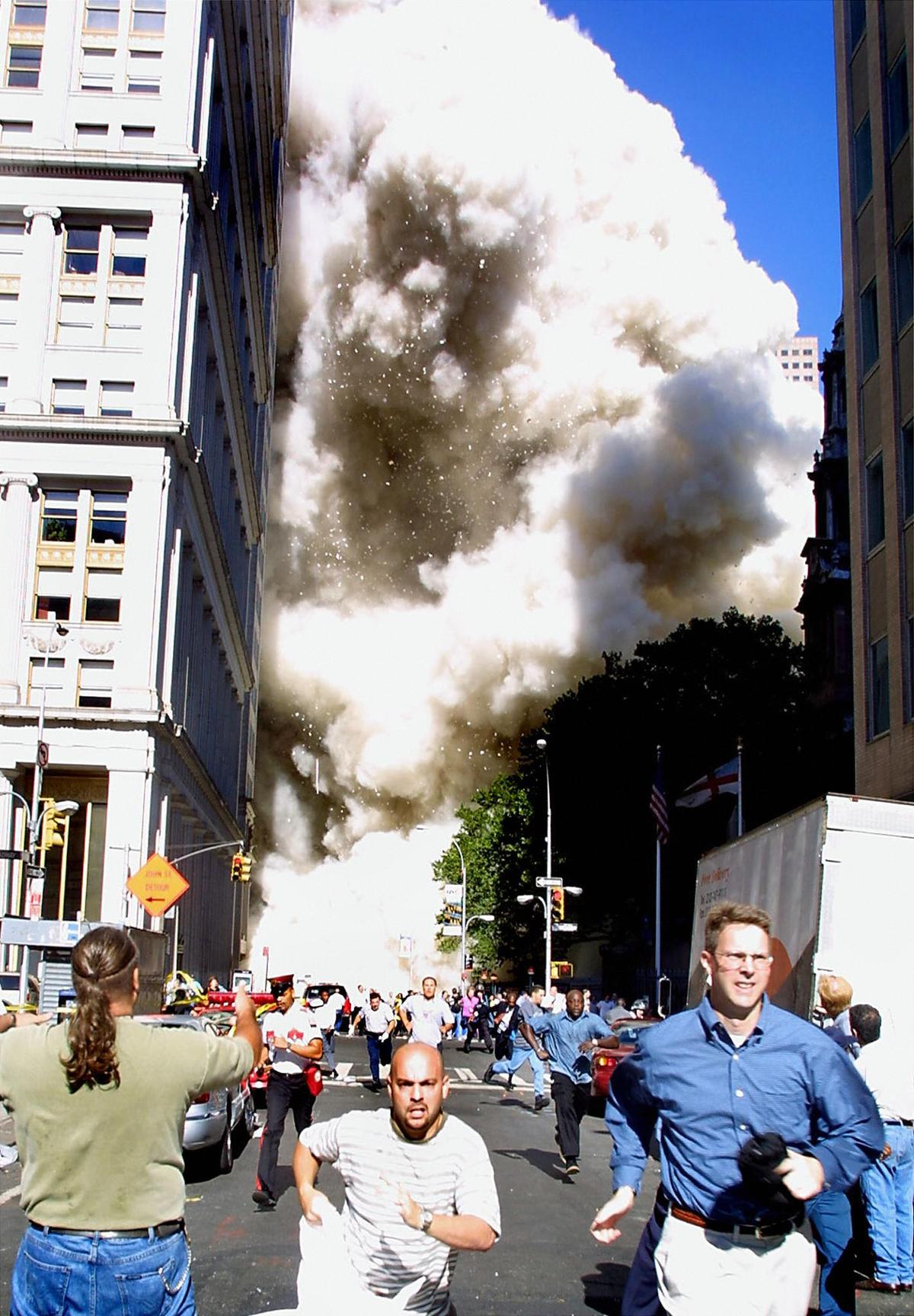 Pedestrians run from the scene as one of the World Trade Center towers collapses in New York City following a terrorist plane crash on the twin towers on Sept. 11, 2001. (Doug Kanter/AFP/Getty Images)