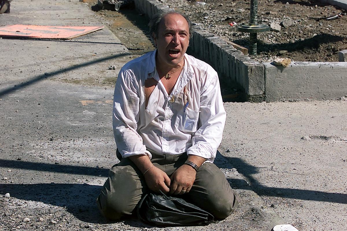 A survivor sits outside the World Trade Center after two planes hit the building in New York City on Sept. 11, 2001. (Jose Jimenez/Primera Hora/Getty Images)