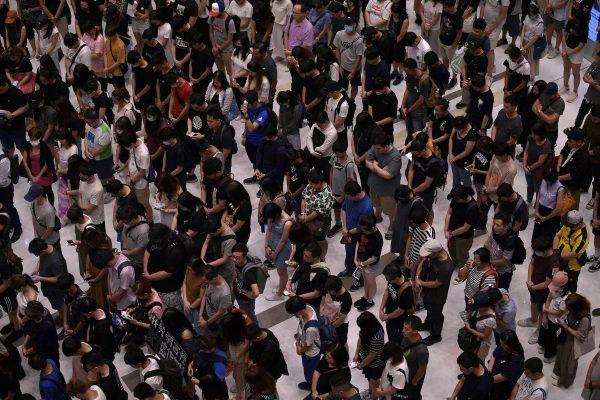 People gather and mark a minute of silence at a shopping mall in the Sha Tin area of Hong Kong on Sept. 11, 2019. (Nicolas Asfouri/AFP/Getty Images)