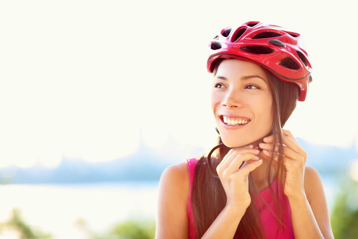 Illustration - Shutterstock | <a href="https://www.shutterstock.com/image-photo/bike-helmet-woman-putting-biking-on-182398502">Maridav</a>