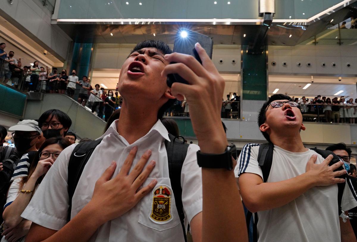 Local residents sing a theme song written by protesters "Glory be to thee" at a shopping mall in Hong Kong on Sept. 11, 2019. (Vincent Yu/AP)