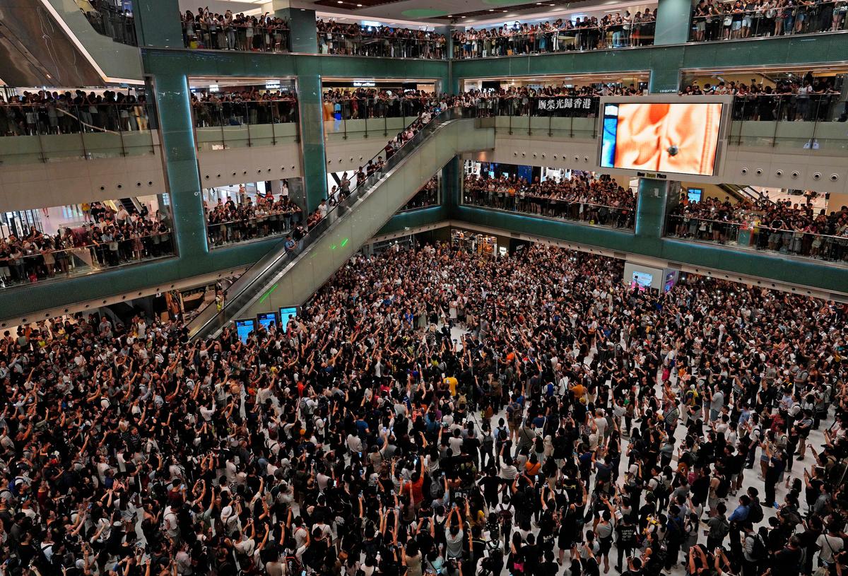 Local residents sing a theme song written by protesters "Glory be to thee" at a shopping mall in Hong Kong on Sept. 11, 2019. (Vincent Yu/AP)