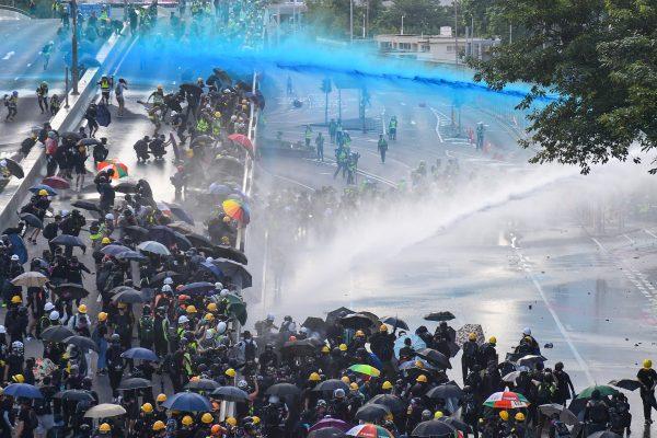 Pro-democracy protesters react as police fire water cannons outside the government headquarters in Hong Kong on Sept. 15, 2019.(Nicolas Asfouri/AFP/Getty Images)