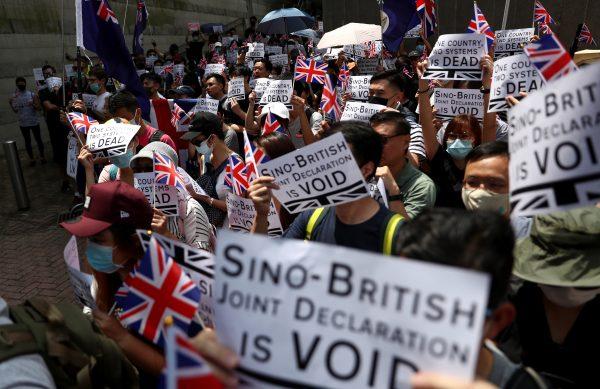 Protesters hold up banners, placards, Union Jack flags as they gather at the British consulate General in Hong Kong, China, on Sept. 15, 2019. (Athit Perawongmetha/Reuters)