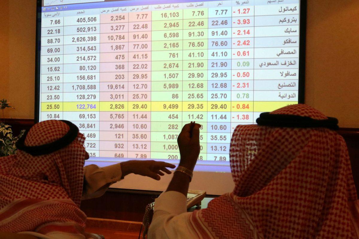 Saudi men look to a screen showing stock prices at ANB Bank, in Riyadh, Saudi Arabia on Sept. 15, 2019. (Stringer/Reuters)
