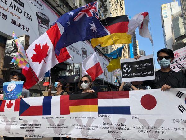 Demonstrators hold different national flags to express appreciation for Western officials and citizens who have voiced support for the Hong Kong protests. (Yu Tianyou/The Epoch Times)