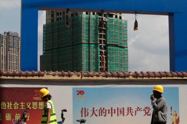 Workers walk past a construction site of residential buildings by property developer Country Garden in Kunming, Yunnan Province, China on Sept. 17, 2019. (Wong Campion/Reuters)