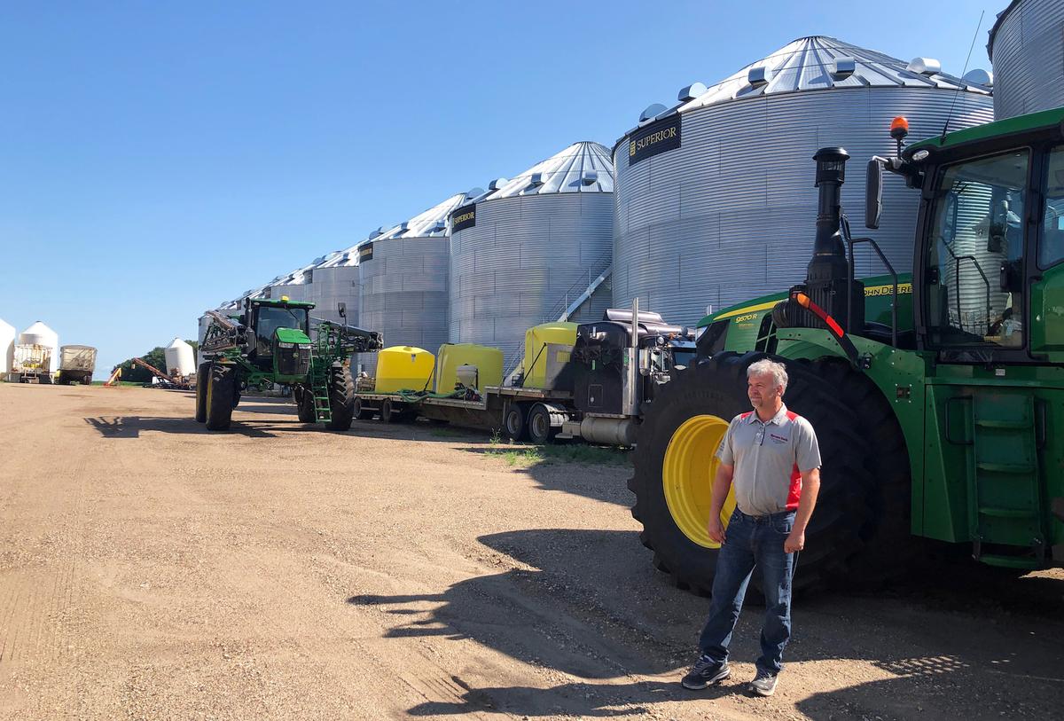 Farmer Mike Appert stands in front of some of his storage bins and machinery on his 48,000-acre farm in Hazelton, North Dakota, U.S. on July 22, 2019. (Mark Weinraub/Reuters)