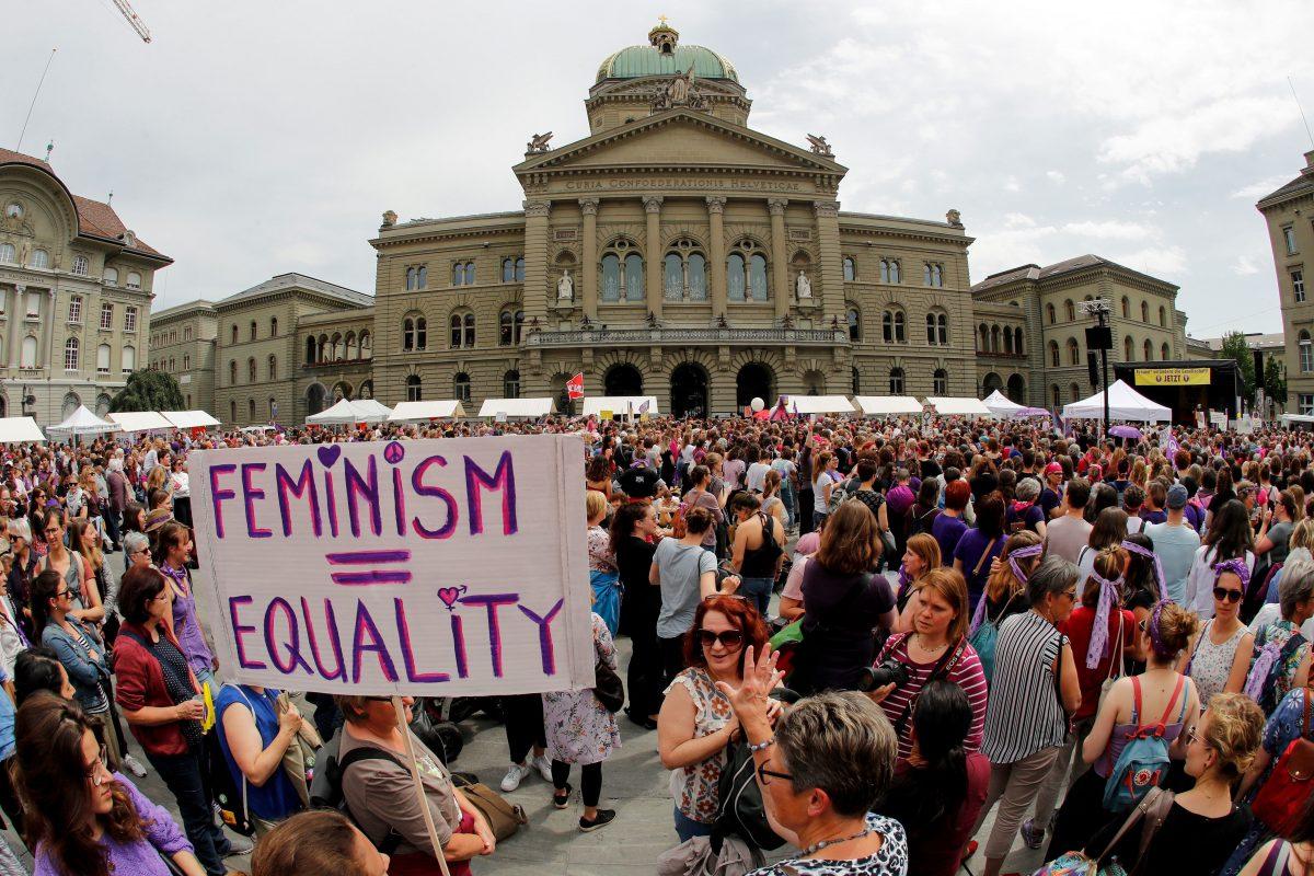 A woman holds a sign reading “Feminism = Equality” as she takes part in a nationwide women’s strike for wage parity outside the federal palace in the Swiss capital Bern, on June 14, 2019. (Stefan Wermuth/AFP/Getty Images)