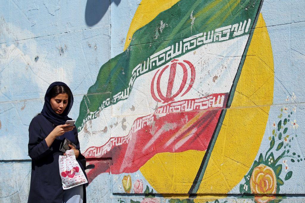 Iranian women walk past a mural depicting the Iranian national flag in a street in Tehran, Sept. 19, 2019. (STR/AFP/Getty Images)